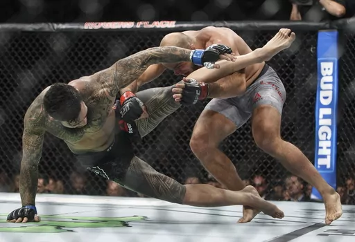 In this Sept. 9, 2017, file photo, ILir Latifi, right, of Sweden, takes down Tyson Pedro, of Australia, during their mixed martial arts bout at UFC 215 in Edmonton, Alberta. Bud Light is set to return as the official beer of UFC in the U.S. next year. Under a new multi-year marketing deal between UFC and Bud Light maker Anheuser-Busch, the brewer will become the mixed martial arts organization's “Official Beer Partner” in the U.S. starting Jan. 1, per a joint announcement on Tuesday, Oct. 24