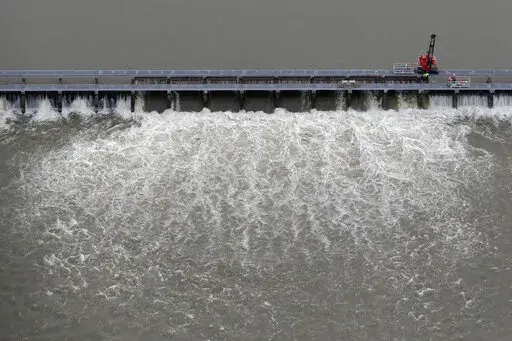 Workers open bays of the Bonnet Carre Spillway to divert rising water from the Mississippi River to Lake Pontchartrain, upriver from New Orleans, in Norco, La., May 10, 2019. A federal judge ruled Wednesday, Jan. 18, 2023, that the U.S. Army Corps of Engineers must consult with federal fisheries experts on the effects of opening the spillway that helped prevented Mississippi River flooding in New Orleans, but caused damage to coastal Mississippi marine life and tourism in 2019. (AP Photo/Gerald 