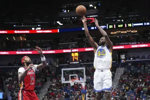 Golden State Warriors forward Andrew Wiggins (22) shoots against New Orleans Pelicans forward Brandon Ingram (14) in the first half of an Emirates NBA Cup basketball game in New Orleans, Friday, Nov. 22, 2024. (AP Photo/Gerald Herbert)