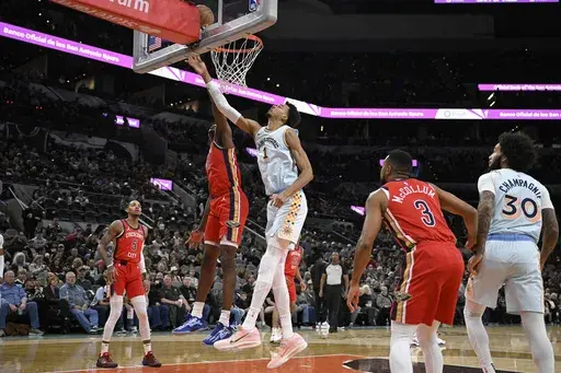 San Antonio Spurs' Victor Wembanyama (1) goes to the basket against New Orleans Pelicans' Yves Missi during the first half of an NBA basketball game, Sunday, Dec. 8, 2024, in San Antonio. (AP Photo/Darren Abate)
