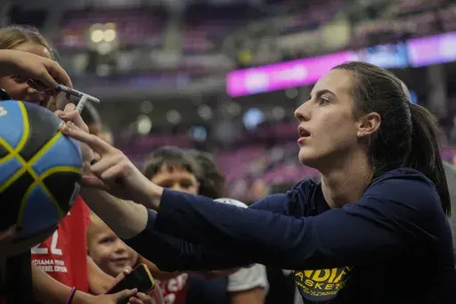 Indiana Fever's Caitlin Clark signs autographs for fans before a WNBA basketball game against the Chicago Sky, Friday, Aug. 30, 2024, in Chicago. (AP Photo/Erin Hooley)