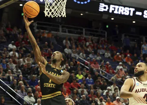 CORRECTS YEAR - Alabama State's Amarr Knox (1) shoots past Auburn's Johni Broome, right, during the second half in the first round of the NCAA college basketball tournament in Lexington, Ky., Thursday, March 20, 2025. (AP Photo/James Crisp)