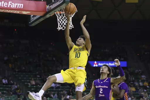 Baylor guard RayJ Dennis shoots next to Northwestern State guard Jamison Epps (2) during the first half of an NCAA college basketball game Saturday, Dec. 2, 2023, in Waco, Texas. (AP Photo/Jerry Larson)