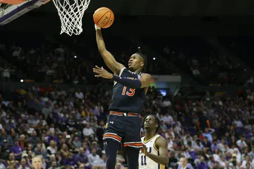 Auburn guard Miles Kelly (13) gets past LSU forward Corey Chest (11) for a breakaway layup during an NCAA college basketball game in Baton Rouge, La., Wednesday, Jan. 29, 2025. (AP Photo/Peter Forest)