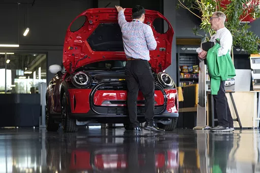 A salesperson shows an unsold 2024 Cooper SE electric hardtop to a prospective buyer at a Mini dealership Wednesday, May 1, 2024, in Highlands Ranch, Colo. On Friday, May 3, 2024, the U.S. government issues its April jobs report. (AP Photo/David Zalubowski)