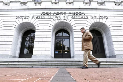 A man walks in front of the 5th U.S. Circuit Court of Appeals on Jan. 7, 2015, in New Orleans. A federal appeals court cleared the way Friday, Aug. 19, 2022, for a lawsuit to proceed against guards and officials at a privately run north Louisiana jail where an inmate died with a fractured skull in 2015. The lawsuit includes allegations that guards at Monroe's Richwood Correctional Center sometimes beat and pepper-sprayed handcuffed prisoners in an area where there were no security cameras. (AP P