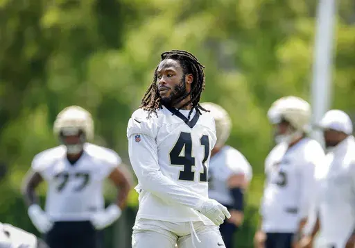 New Orleans Saints running back Alvin Kamara (41) takes off his helmet during the team's NFL mini-camp football practice in Metairie, La., June 11, 2024. Kamara reported for training camp Tuesday, July 23, 2024, in Irvine, California, after leaving the team's June minicamp early because of an ongoing contract dispute. (Sophia Germer/The Times-Picayune/The New Orleans Advocate via AP, File)