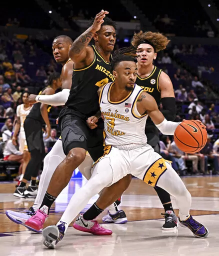 LSU guard Justice Hill (3) moves the ball around Missouri guard DeAndre Gholston (4) and forward Noah Carter during an NCAA college basketball game Wednesday, March 1, 2023, in Baton Rouge, La. (Hilary Scheinuk/The Advocate via AP)