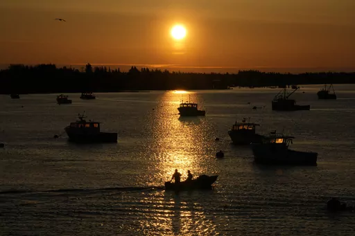 Lobstermen motor out to their moored fishing boat in Jonesport, Maine, Thursday, April 28, 2023. The fishing industry is a major employer in the rural area where a local family wants to build the world's tallest flagpole. Situated at the nation’s eastern tip, Maine’s Down East region is the place where the sunlight first kisses U.S. soil each day. (AP Photo/Robert F. Bukaty)