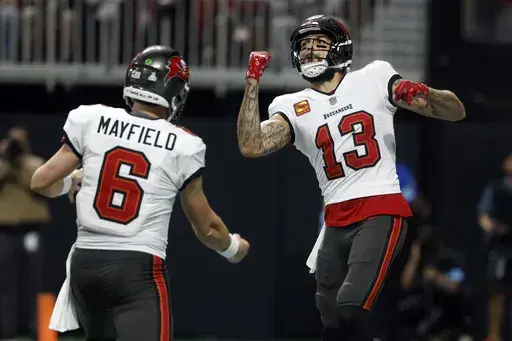 Tampa Bay Buccaneers wide receiver Mike Evans (13) celebrates with quarterback Baker Mayfield (6) after scoring against the Atlanta Falcons during the first half of an NFL football game Thursday, Oct. 3, 2024, in Atlanta. (AP Photo/Butch Dill)
