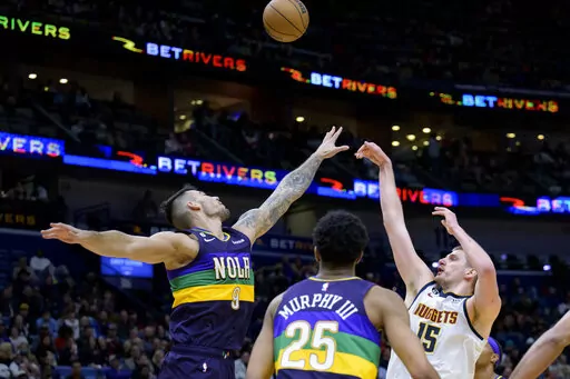 Denver Nuggets center Nikola Jokic (15) shoots over New Orleans Pelicans center Willy Hernangomez (9) in the second half of an NBA basketball game in New Orleans, Tuesday, Jan. 24, 2023. (AP Photo/Matthew Hinton)