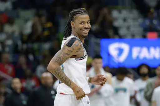 Memphis Grizzlies guard Ja Morant (12) smiles after a three-point basket during the fourth quarter of an NBA basketball game against the New Orleans Pelicans in New Orleans, Sunday, March 9, 2025. (AP Photo/Matthew Hinton)