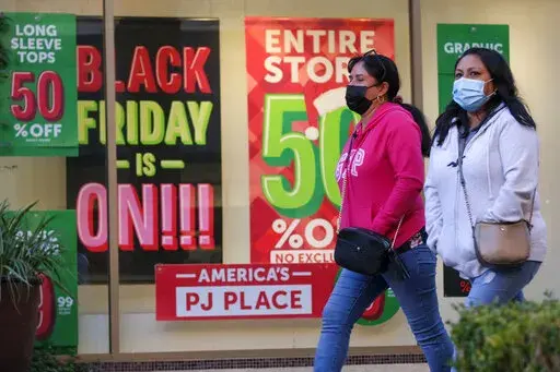 Black Friday shoppers wearing face masks shop at the Citadel Outlets in Commerce, Calif., Friday, Nov. 26, 2021. Given higher prices and economic uncertainty, consumers face a lot of pressure this year when it comes to Black Friday and holiday season shopping. (AP Photo/Ringo H.W. Chiu, File)