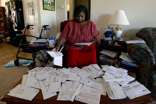 Debra Smith sorts through her medical bills in her living room on Thursday, Oct. 7, 2021, in Spring Hill, Tenn. Medical bills can quickly become overwhelming, but consumers often have more power than they might think when it comes to navigating them. (AP Photo/Mark Zaleski, File)