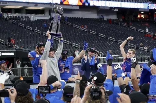Boise State interim head coach Spencer Danielson holds up the trophy after winning the Mountain West championship NCAA college football game against UNLV, Dec. 2, 2023, in Las Vegas. (Steve Marcus/Las Vegas Sun via AP, File)