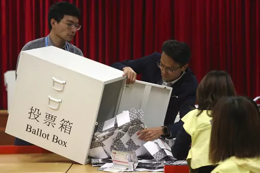 Election workers empty a ballot box to count votes for a district council election at a polling station in Hong Kong, Nov. 24, 2019. Hong Kong's leader on Tuesday, May 2, 2023, stepped up a campaign to shut down democratic challenges by unveiling plans to eliminate most directly elected seats on local district councils, the last major political representative bodies mostly chosen by the public. (AP Photo/Ng Han Guan, File)