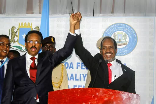 Hassan Sheikh Mohamud, right, marks his election win with incumbent leader Mohamed Abdullahi Mohamed, left, at the Halane military camp in Mogadishu, Somalia, Sunday, May 15, 2022. Former President Mohamud, who was voted out of power in 2017, has been returned to the nation's top office after defeating the incumbent leader in a protracted contest decided by legislators in a third round of voting late Sunday. (AP Photo/Farah Abdi Warsameh)