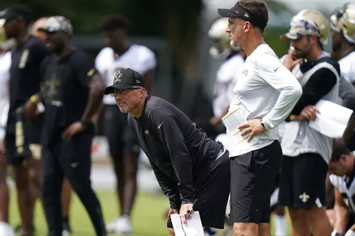 New Orleans Saints offensive coordinator Pete Carmichael and head coach Dennis Allen, right, watch during training camp at their NFL football training facility in Metairie, La., Thursday, July 28, 2022. For all but one year since 2006, recently retired Saints coach Sean Payton has overseen the offensive  game plan and has usually called plays on game days. This weekend in Atlanta, the Saints debut an offense now run exclusively by long-time Payton understudy Pete Carmichael Jr. (AP Photo/Gerald 