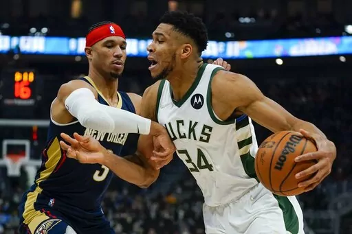 Milwaukee Bucks' Giannis Antetokounmpo tries to drive past New Orleans Pelicans' Willy Hernangomez during the first half of an NBA basketball game Saturday, Jan. 1, 2022, in Milwaukee. (AP Photo/Morry Gash)