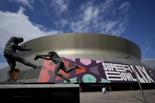People walk outside the Caesars Superdome, Friday, Jan. 31, 2025, in New Orleans prior to the NFL Super Bowl 59 football game between the Philadelphia Eagles and the Kansas City Chiefs. (AP Photo/Matt York)