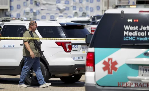 Law enforcement officers work at the St. Germain Apartments in the 2200 block of Manhattan Boulevard in Harvey, La., Monday, July 17, 2023. A man suspected of killing two former co-workers earlier in the day at a shipyard near New Orleans was shot to death hours later by deputies in an afternoon gunfight at the apartment complex. (Brett Duke/The Times-Picayune/The New Orleans Advocate via AP)