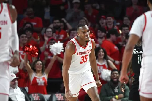 Houston forward Fabian White Jr. (35) smiles after dunking the ball against Tulane during the first half of an NCAA college basketball game Wednesday, Feb. 2, 2022, in Houston. (AP Photo/Justin Rex)