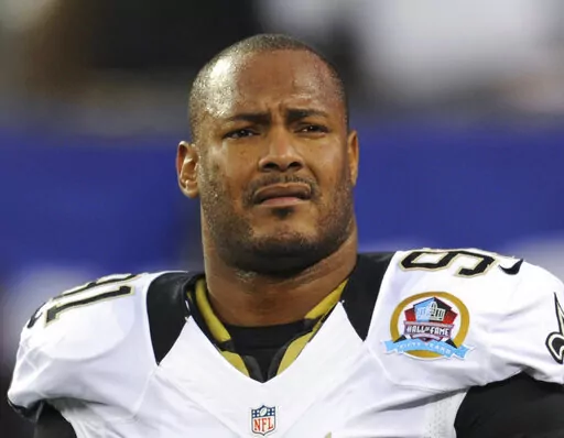 In this Dec. 9, 2012, file photo, New Orleans Saints defensive end Will Smith appears before an NFL football game against the New York Giants in East Rutherford, N.J.  The man convicted of killing Smith and wounding his wife during an argument in New Orleans will go on trial again in August after his conviction was overturned. Orleans Parish Criminal District Judge Camille Buras on Monday, April 4, 2022, set the Aug. 22 date for Cardell Hayes’ retrial after a conference with Hayes’ attorney,