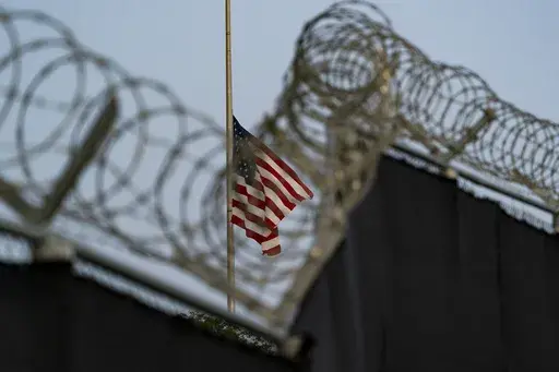 In this Aug. 29, 2021, file photo reviewed by U.S. military officials, a flag flies at half-staff as seen from Camp Justice in Guantanamo Bay Naval Base, Cuba. (AP Photo/Alex Brandon, File)