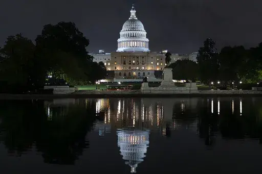 The Capitol is seen in the reflecting pool as lawmakers work into the evening, in Washington, Monday, Sept. 23, 2024. (AP Photo/J. Scott Applewhite, File)