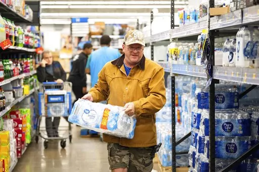 John Beezley, of Bonham, buys cases of water after learning that a boil water notice was issued for the entire city of Houston on Sunday, Nov. 27, 2022, at Walmart on S. Post Oak Road in Houston. Beezley just arrived in town with his wife, who is undergoing treatment starting tomorrow at M.D. Anderson Cancer Center, where they are staying in a camping trailer. They turned on the television after settling in and saw that a boil water notice had been issued. Beezley decided to go out immediately f