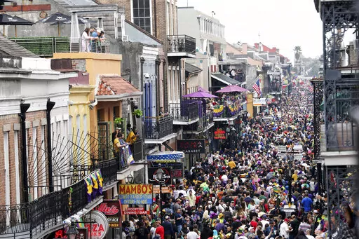 Crowds are seen packing Bourbon Street on Mardi Gras day in New Orleans on Feb. 25, 2020. More than 100 people have joined a lawsuit against New Orleans’ mayor and health director over COVID-19 restrictions that recently were extended to parade and other participants on Mardi Gras and during the season leading up to it. The 2020 festival was recognized as a super spreader that turned New Orleans into an early pandemic hot spot. Last season, parades were canceled and bars were shuttered in the 