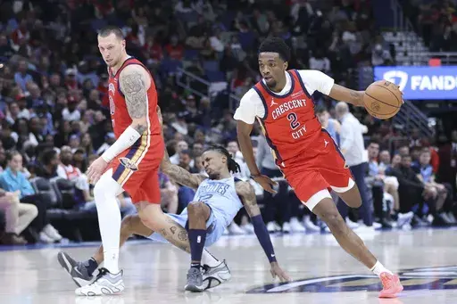 New Orleans Pelicans forward Herbert Jones (2) drives to the basket while center Daniel Theis, left, sets a hard pick against Memphis Grizzlies guard Ja Morant (12) in the second half of an NBA basketball game in New Orleans, Friday, Dec. 27, 2024. Morant was injured on the play. (AP Photo/Peter Forest)