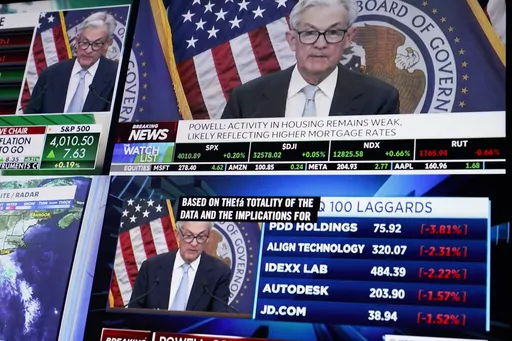 Displays show Fed chairman Jerome Powell's news conference while traders work on the floor at the New York Stock Exchange in New York, Wednesday, March 22, 2023. (AP Photo/Seth Wenig)