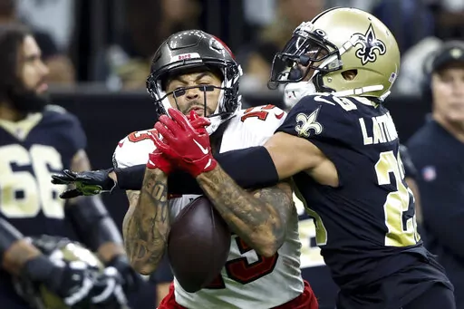 New Orleans Saints cornerback Marshon Lattimore breaks up a pass intended for Tampa Bay Buccaneers wide receiver Mike Evans during the first half of an NFL football game in New Orleans, Sunday, Sept. 18, 2022. (AP Photo/Butch Dill)