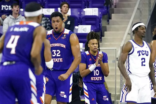 Northwestern State center Jordan Wilmore (32) reacts to scoring with Greedy Williams (10) and other teammates as TCU forward Emanuel Miller (2) looks away during the second half of an NCAA college basketball game in Fort Worth, Texas, Monday, Nov. 14, 2022. Northwestern State won 64-63. (AP Photo/LM Otero)