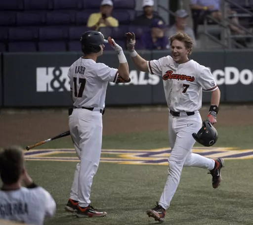 Oregon State's Mikey Kane (7) celebrates with right fielder Brady Kasper (17) after scoring against Sam Houston State during an NCAA college baseball tournament regional game Friday, June 2, 2023, in Baton Rouge, La. (Hilary Scheinu/The Advocate via AP)
