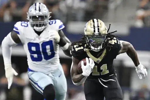 New Orleans Saints running back Alvin Kamara (41) breaks away with Dallas Cowboys defensive end DeMarcus Lawrence (90) in tow while running for a long touchdown during the first half of an NFL football game, Sunday, Sept. 15, 2024, in Arlington, Texas. (AP Photo/Tony Gutierrez)