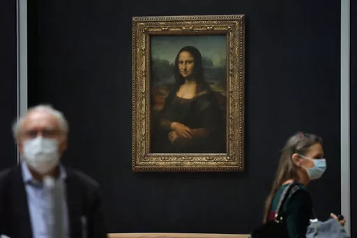 Journalists walk past Leonardo da Vinci's Mona Lisa during a visit of the Louvre museum Tuesday, June 23, 2020. Using X-rays to peer into the chemical structure of a tiny speck of the celebrated work of art, scientists have gained new insight into the techniques that Leonardo da Vinci used to paint his groundbreaking portrait of the woman with the exquisitely enigmatic smile. (AP Photo/Christophe Ena, File)