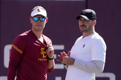 Southern California head coach Lincoln Riley, left, talks with defensive coordinator Alex Grinch during an NCAA college football practice Thursday, March 24, 2022, in Los Angeles. USC has created more turnovers and had more sacks in its first season with defensive coordinator Alex Grinch. (AP Photo/Mark J. Terrill)