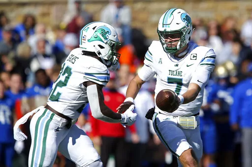 Tulane quarterback Michael Pratt, right, hands the ball to running back Tyjae Spears during the first half of an NCAA college football game against Tulsa in Tulsa, Okla. on Saturday, Nov. 5, 2022. (AP Photo/Dave Crenshaw)