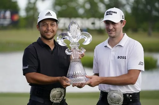 Xander Schauffele, left, and Patrick Cantlay, right, hold up the trophy after winning the PGA Zurich Classic golf tournament at TPC Louisiana in Avondale, La., Sunday, April 24, 2022. The Zurich Classic's unusual two-player team format has attracted a field featuring some of the PGA's most accomplished players -- even without the big purse of an elevated event. Defending champions Cantlay and Schauffele will be up against teams featuring former major winners, including Matt Fitzpatrick with his 