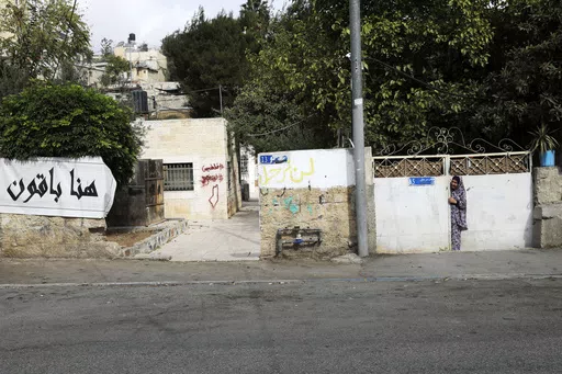 A Palestinian resident of the Sheikh Jarrah neighborhood of east Jerusalem stands near a sidewalk, Nov. 2, 2021. An Israeli court on Monday, April 15, 2024 ordered the eviction of a Palestinian family in the contested neighborhood of east Jerusalem, the latest in a legal saga that has come to symbolize the conflicting claims to the holy city. (AP Photo/Mahmoud Illean, file)