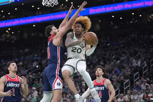 Boston Celtics guard JD Davison (20) drives toward the basket as Washington Wizards forward Anthony Gill, center left, defends in the first half of an NBA basketball game, Sunday, April 14, 2024, in Boston. (AP Photo/Steven Senne)