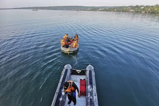 In this photo provided by the National Search and Rescue Agency (BASARNAS), rescuers on a rubber boat search for survivors after an overloaded ferry sank off Sulawesi Island, Indonesia, Monday, July 24, 2023. (BASARNAS via AP)