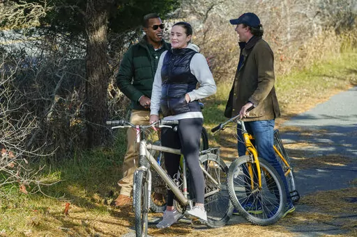 Naomi Biden, second from left, and her fiancé Peter Neal, right, stop on bikes in Nantucket, Mass., Nov. 25, 2021, for President Joe Biden and first lady Jill Biden to pass in a motorcade. Naomi Biden, the daughter of President Joe Biden's son Hunter, is planning to celebrate her wedding at the White House on Nov. 19. Naomi Biden tweeted that she is "endlessly grateful" to her "Nana and Pop" for the opportunity to celebrate her wedding at the White House."(AP Photo/Carolyn Kaster, File)