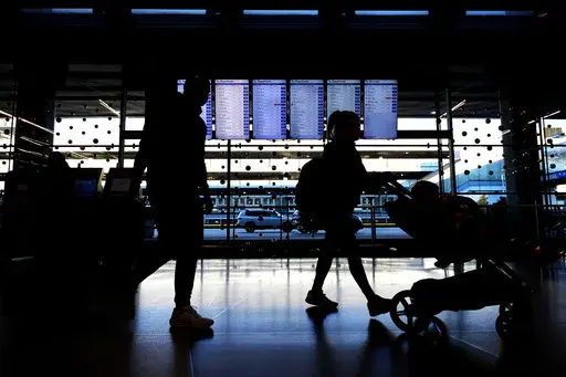 Travelers walk through Terminal 3 at O'Hare International Airport in Chicago, Tuesday, Nov. 26, 2024. (AP Photo/Nam Y. Huh)