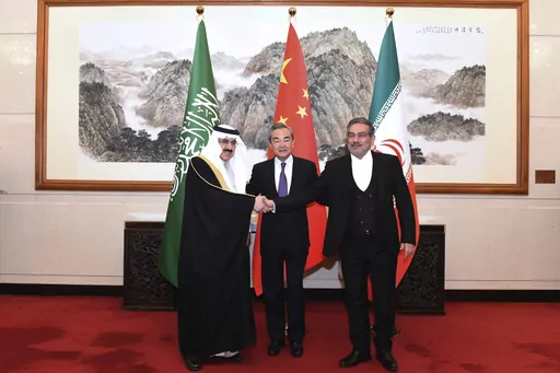 In this photo released by Xinhua News Agency, Ali Shamkhani, the secretary of Iran's Supreme National Security Council, at right, shakes hands with Saudi national security adviser Musaad bin Mohammed al-Aiban, at left, as Wang Yi, China's most senior diplomat, looks on, at center, for a photo during a closed meeting held in Beijing, Saturday, March 11, 2023. Iran and Saudi Arabia agreed Friday to reestablish diplomatic relations and reopen embassies after seven years of tensions. The major diplo