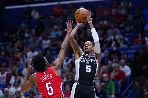San Antonio Spurs guard Dejounte Murray (5) shoots against New Orleans Pelicans forward Herbert Jones (5) in the first half of an NBA basketball game in New Orleans, Saturday, March 26, 2022. (AP Photo/Gerald Herbert)