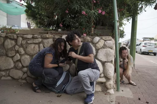 Israelis take cover from the incoming rocket fire from the Gaza Strip in Ashkelon, southern Israel on Oct. 11, 2023. (AP Photo/Leo Correa, File)