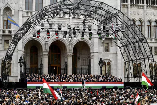 Hungary's right-wing populist prime minister, Viktor Orban addresses thousands of supporters as they gather in Budapest, Hungary, Tuesday, March 15, 2022. The so-called "peace march" was a show of strength by Orban's supporters ahead of national elections scheduled for April 3, while a coalition of six opposition parties also held a rally in the capital. (AP Photo/Anna Szilagyi)